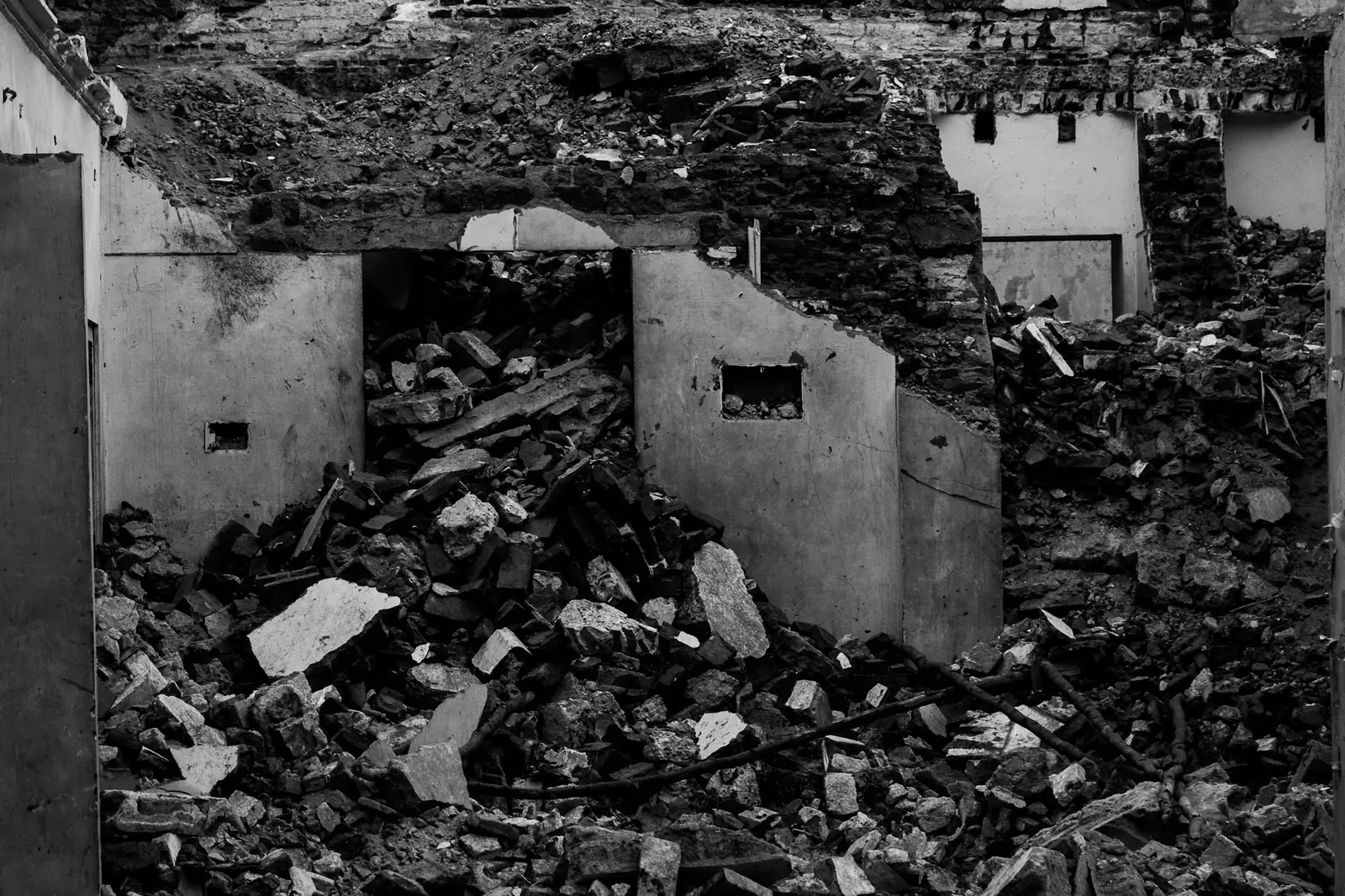 Black and white photo of a demolished house reduced to rubble